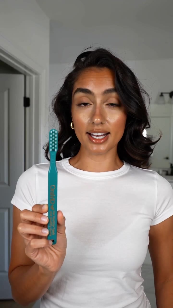 Présentatrice générée par IA tenant la brosse à dents Dr. Bass OraMD